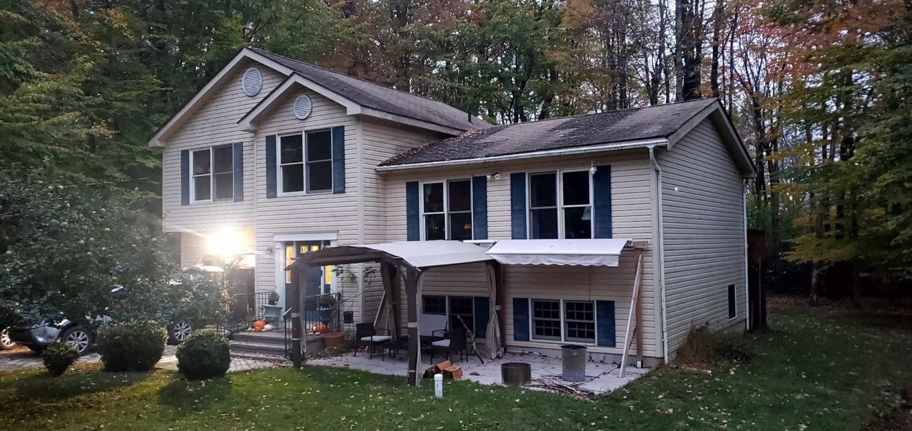Split-level home before roof replacement, with a worn, streaked and moss-stained roof