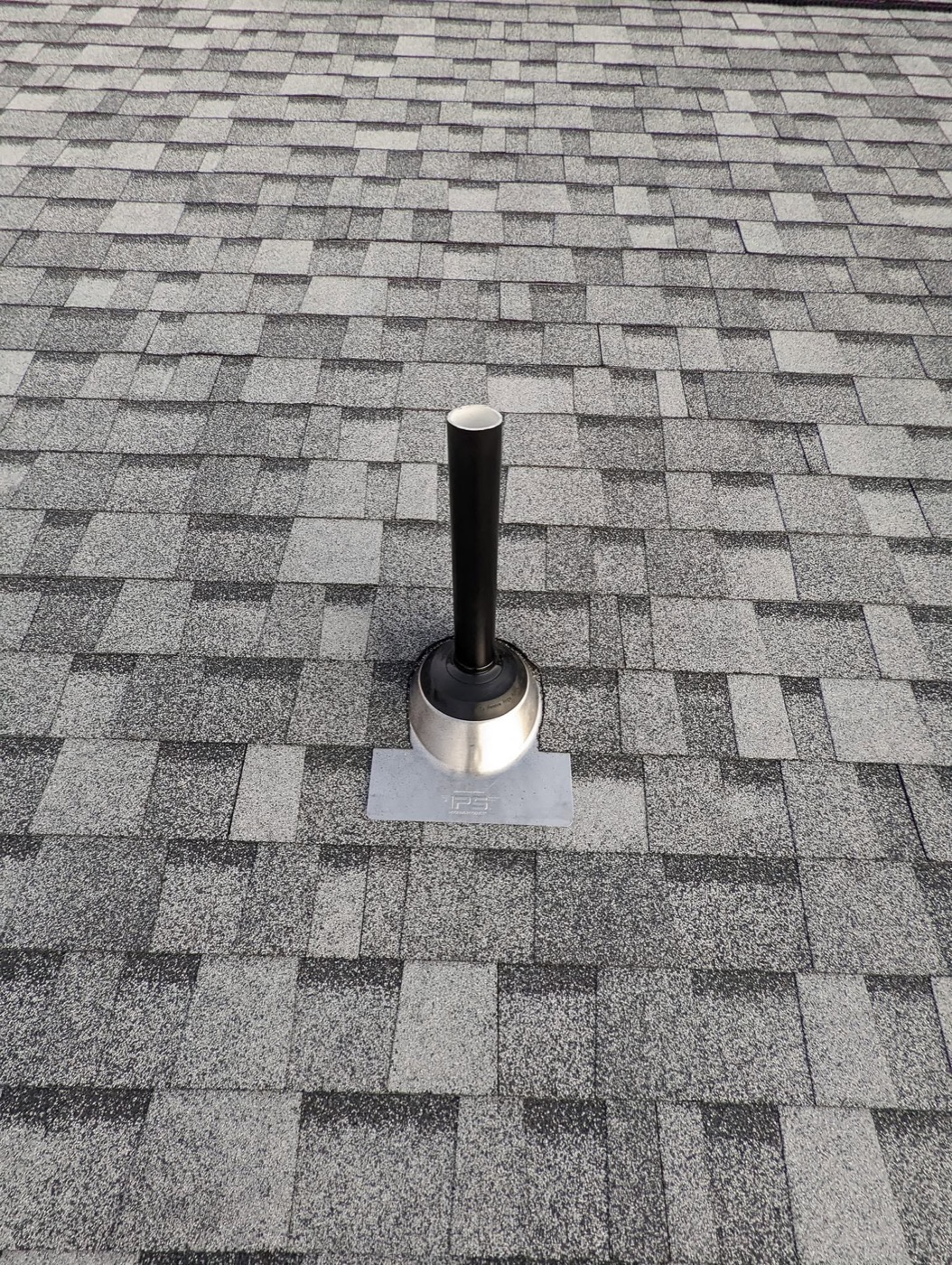 Close-up of a new architectural shingle layer with a sealed pipe boot