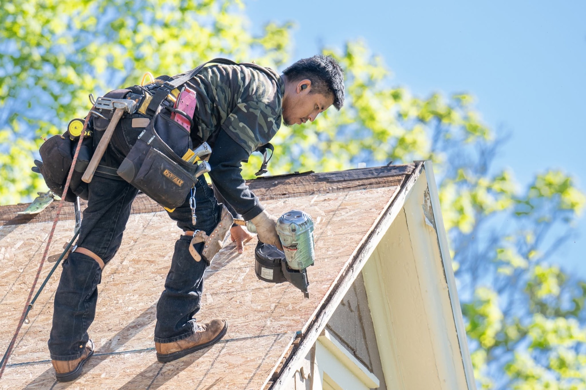 Rail Roofing Group roofer securing new roof decking with a nail gun at the gable edge